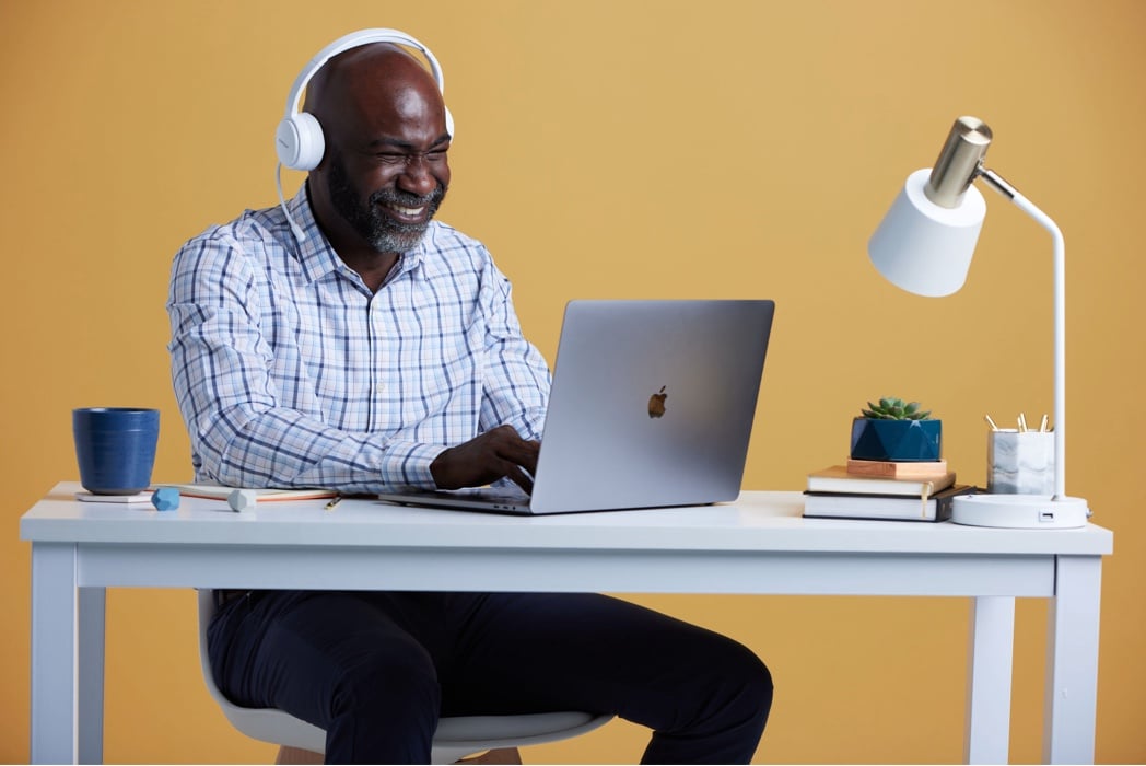 man at computer with headphones